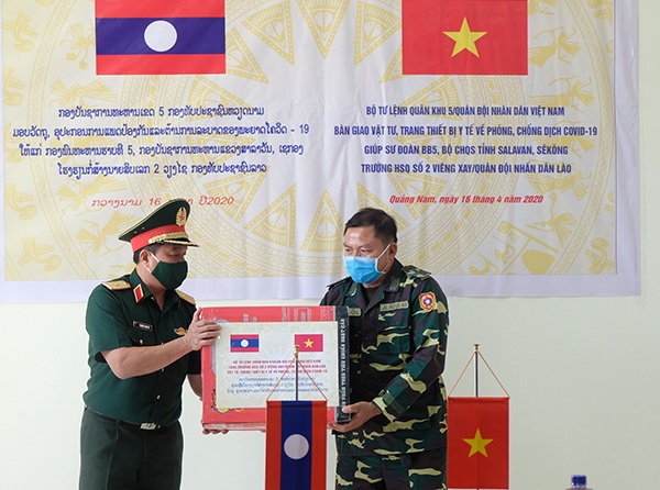 Lãnh đạo Quân khu 5 (bên trái) trao tặng trang thiết bị vật tư y tế cho Bộ CHQS tỉnh Salavan và Sê Kông (Lào).
