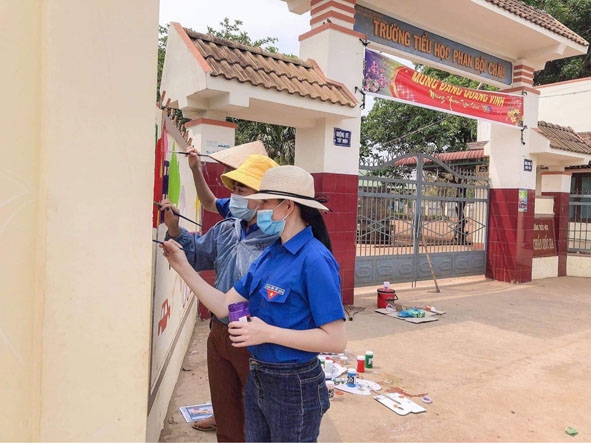 Đoàn viên, thanh niên xã Ea Drơng vẽ công trình bích họa ở tường rào khu vực cổng Trường Tiểu học Phan Bội Châu.