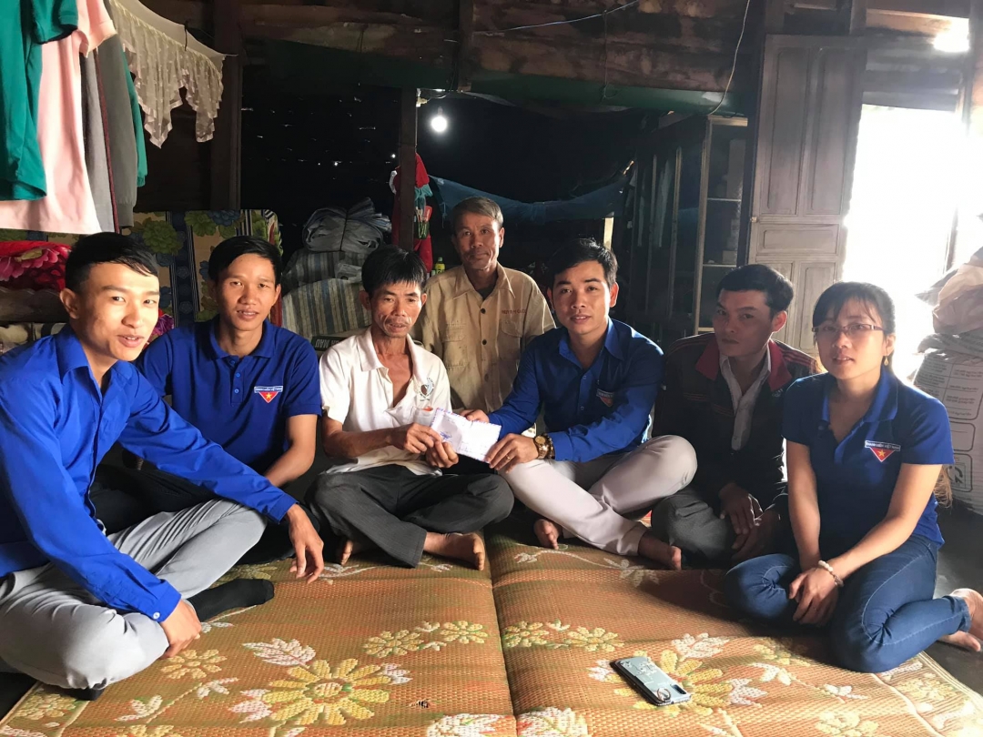 Anh Bùi Văn An (thứ ba từ phải sang) trao tiền hỗ trợ cho gia đình hộ nghèo bị tai nạn lao động trên địa bàn xã