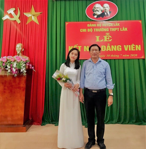 Thầy Lê Văn Trị,  Bí thư Chi bộ, Hiệu trưởng Trường THPT Lắk  tặng hoa  chúc mừng  đảng viên mới. (Ảnh do  nhà trường cung cấp).  