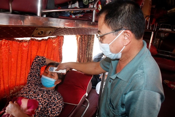 Nhân viên nhà xe Minh Tâm tuyến Bình Dương - Phú Thọ đo thân nhiệt cho hành khách.
