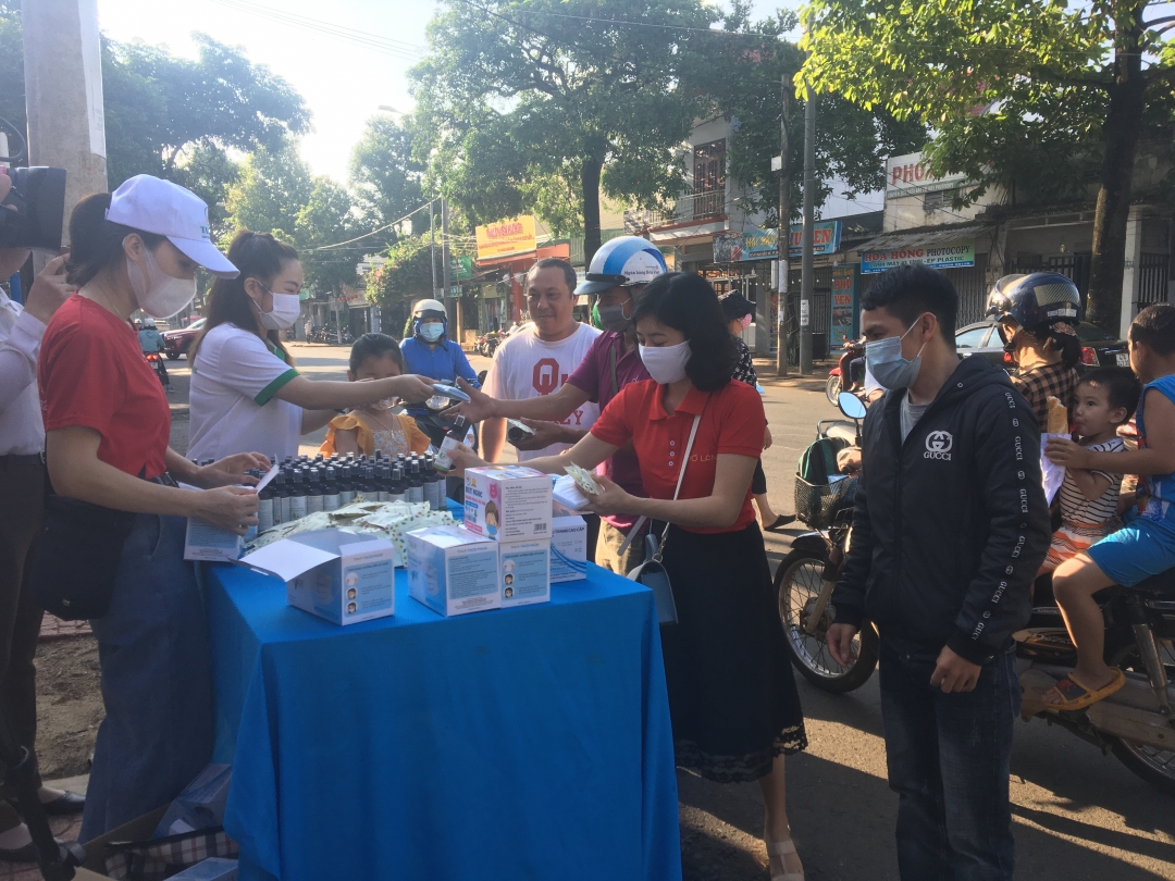 Các tình nguyện viên phát sản phẩm phòng chống dịch cho người dân trước cổng UBND phường Tân Thành, TP. Buôn Ma Thuột