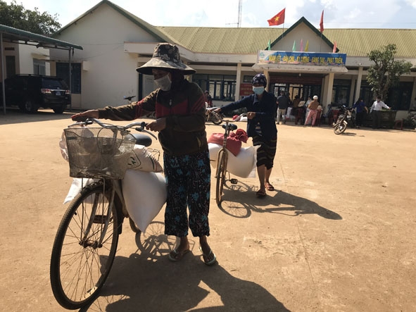 Người dân  xã Ea Hiu (huyện Krông Pắc) nhận gạo hỗ trợ mùa giáp hạt.