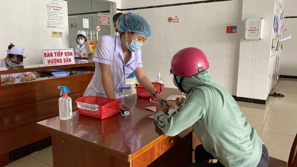 Nhân viên y tế Bệnh viện Đa khoa vùng Tây Nguyên hướng dẫn người dân khai báo y tế. 