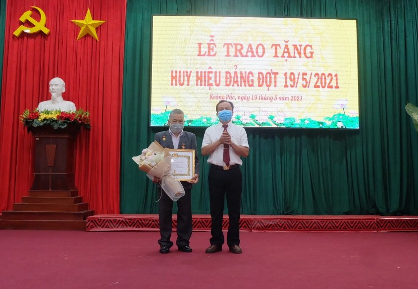 Phó Bí thư Thường trực Huyện ủy Trần Quốc Vĩnh trao huy hiệu 65 tuổi Đảng