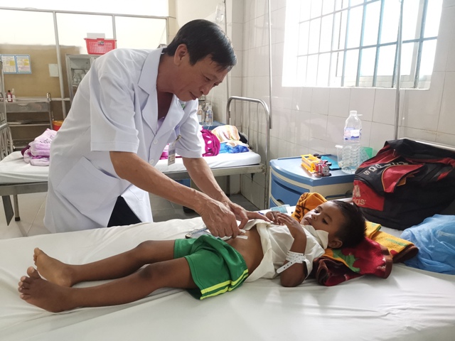 Bác sĩ CKI Ngô Quang Vinh kiểm tra vết mổ cho cháu Y Ba Niê.