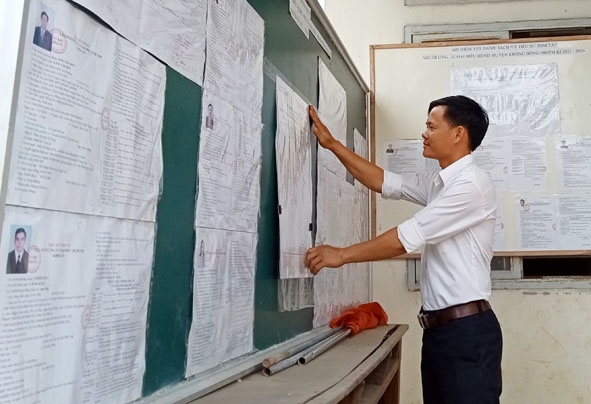 Ông Nguyễn Hữu Tùng, Phó Bí thư Chi bộ thôn Điện Tân, Tổ trưởng Tổ bầu cử số 5 (xã Cư Pui, huyện Krông Bông) niêm yết danh sách cử tri tại khu vực bỏ phiếu. 