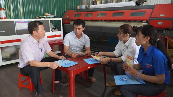 Cán bộ BHXH huyện Krông Búk (bìa trái) tuyên truyền cho người dân về lợi ích của ứng dụng VssID.  Ảnh: N.Quỳnh