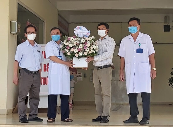 Bệnh nhân 3836 (người thứ hai từ phải sang) tặng hoa tri ân các y bác sĩ trong ngày xuất viện về với gia đình.