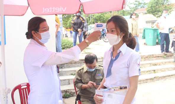 Lực lượng y tế đo thân nhiệt cho các thí sinh ở huyện M'Drắk trước khi bước vào phòng thi. 