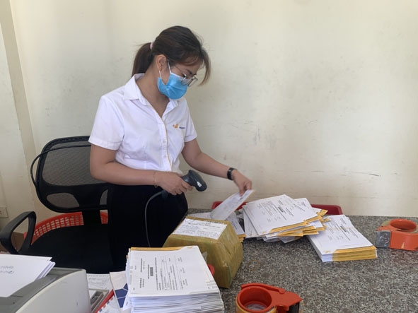 Nhân viên Bưu điện huyện Lắk quét mã vận đơn để phân cho các tuyến phát.  