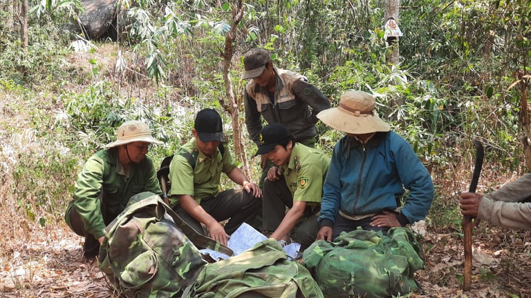 Lực lượng kiểm lâm VQG Chư Yang Sin trao đổi công việc với người dân nhận khoán rừng trong một chuyến tuần tra, bảo vệ rừng