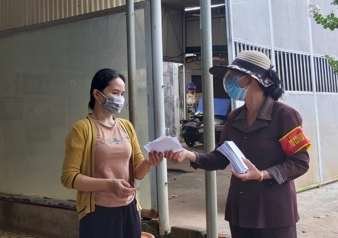 Tổ trưởng tổ dân phố 6, phường Tân An (TP. Buôn Ma Thuột) phát phiếu đi chợ  cho một hộ dân trên địa bàn. 