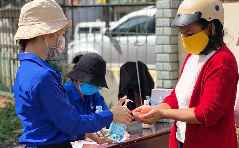 Người dân thực hiện khai báo y tế và rửa tay sát khuẩn trước khi vào làm việc tại trụ sở UBND xã Ea Yông